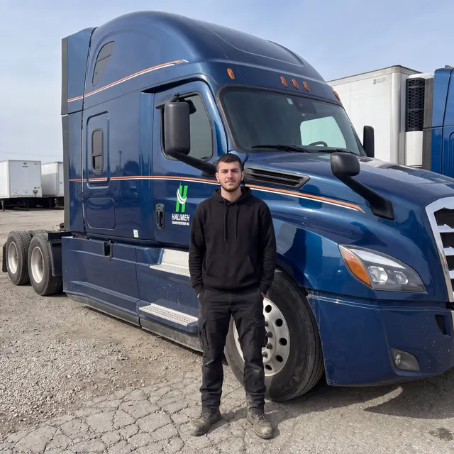 Truck driver standing with a Halimeh Transportation Inc truck