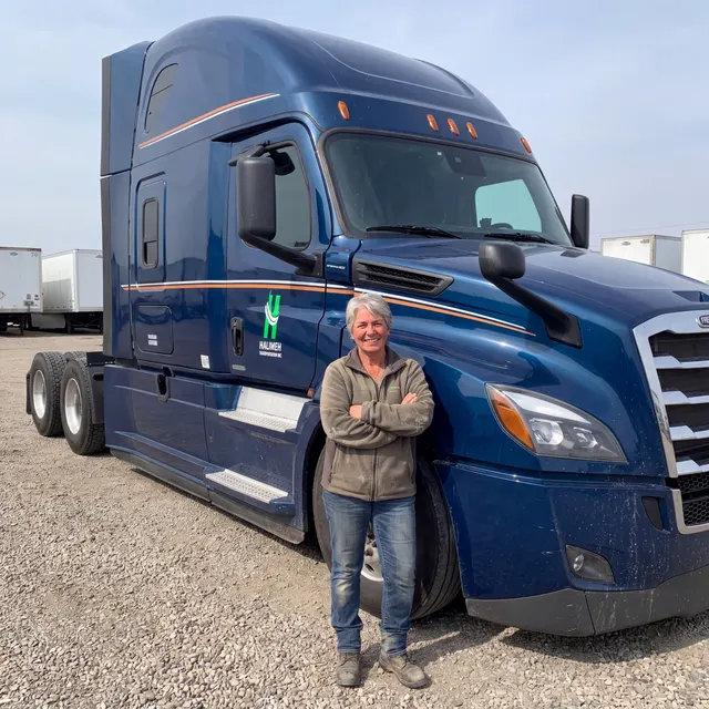 Truck driver standing with a Halimeh Transportation Inc truck